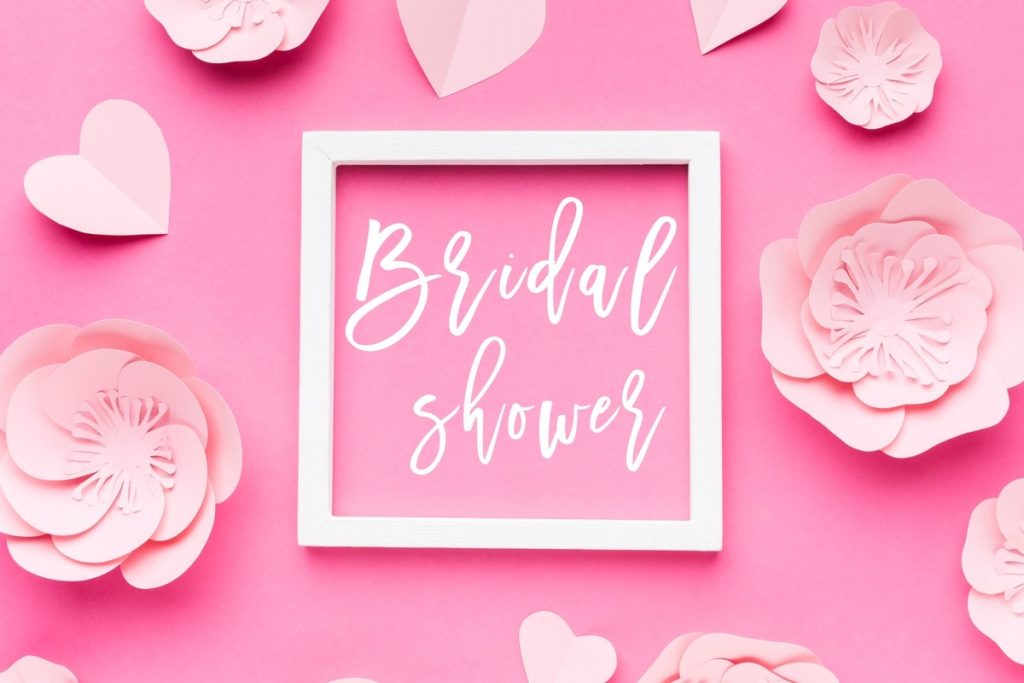 Pink bridal shower decorations with paper flowers and hearts