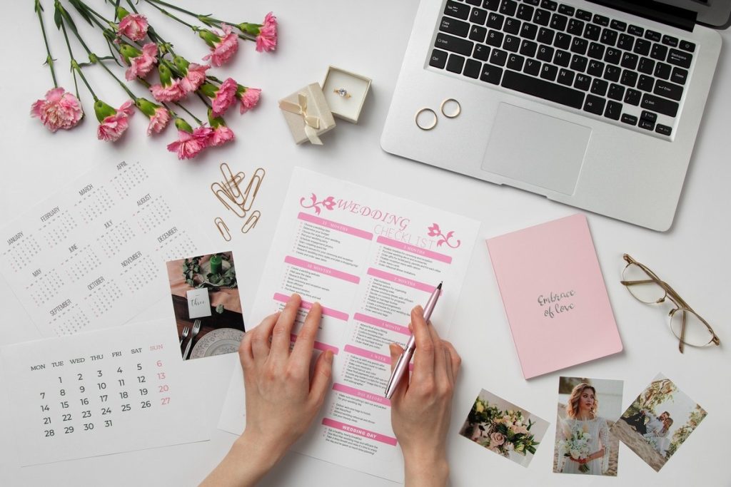 How to plan a bridal shower with a step-by-step checklist, flowers, photos, and laptop on a desk.