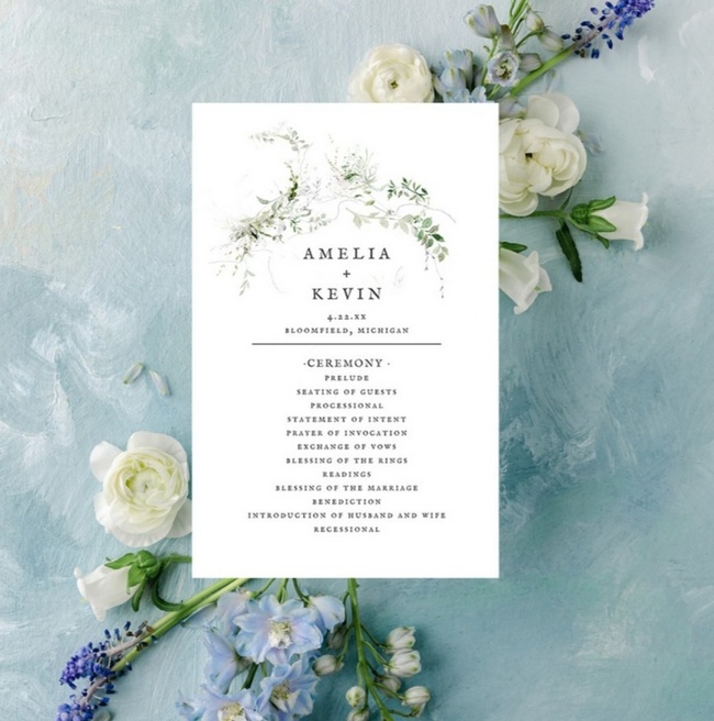 Elegant greenery watercolor wedding program with floral accents on blue background