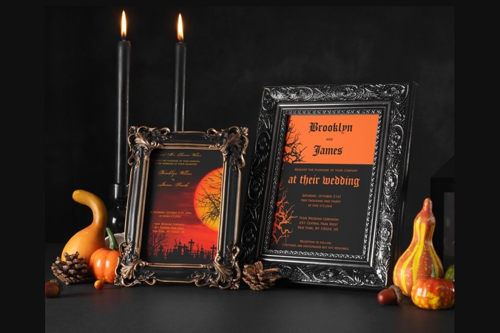 Halloween wedding invitations in ornate black frames, styled with black taper candles, autumn gourds, and pumpkins on a dark background.