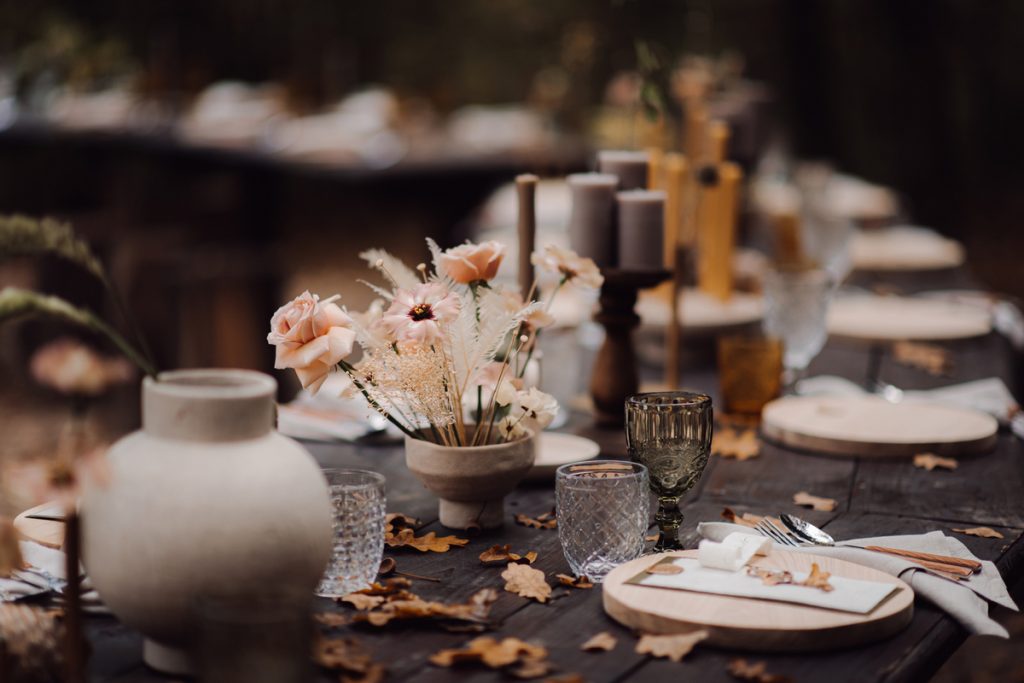 Rustic wedding table setting with florals and candles, perfect for a fall-themed celebration inspired by a rustic save the date card.