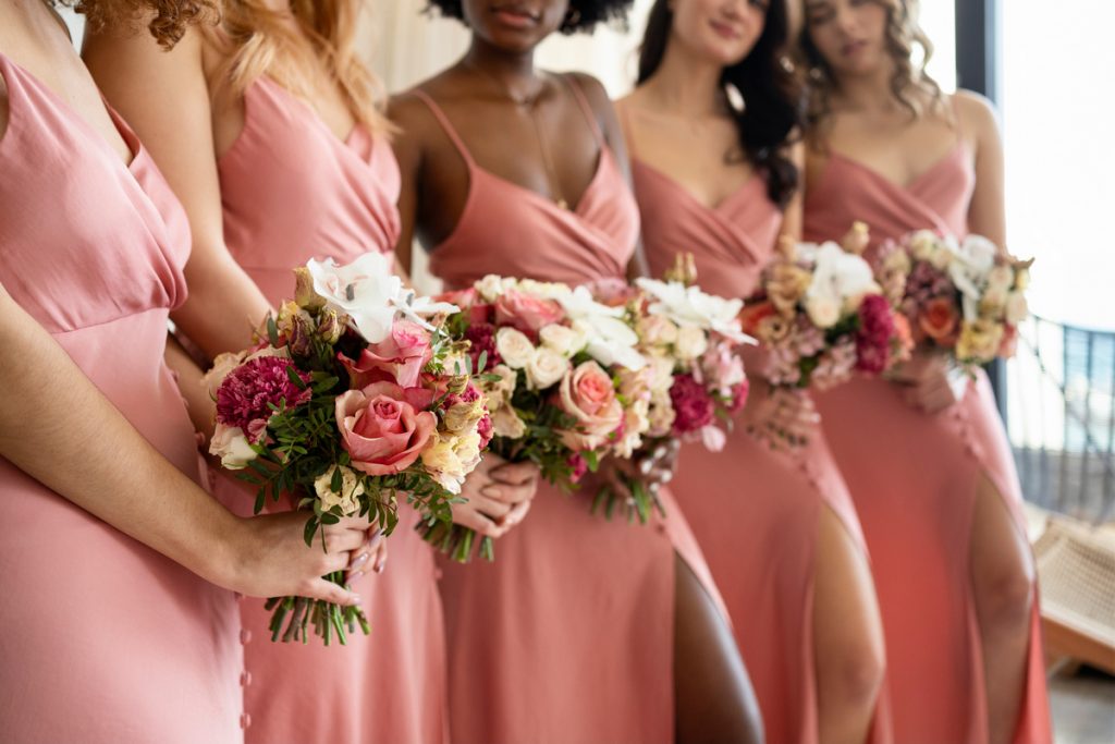 Bridesmaids in blush pink dresses holding floral bouquets as part of bridal shower planning inspiration.