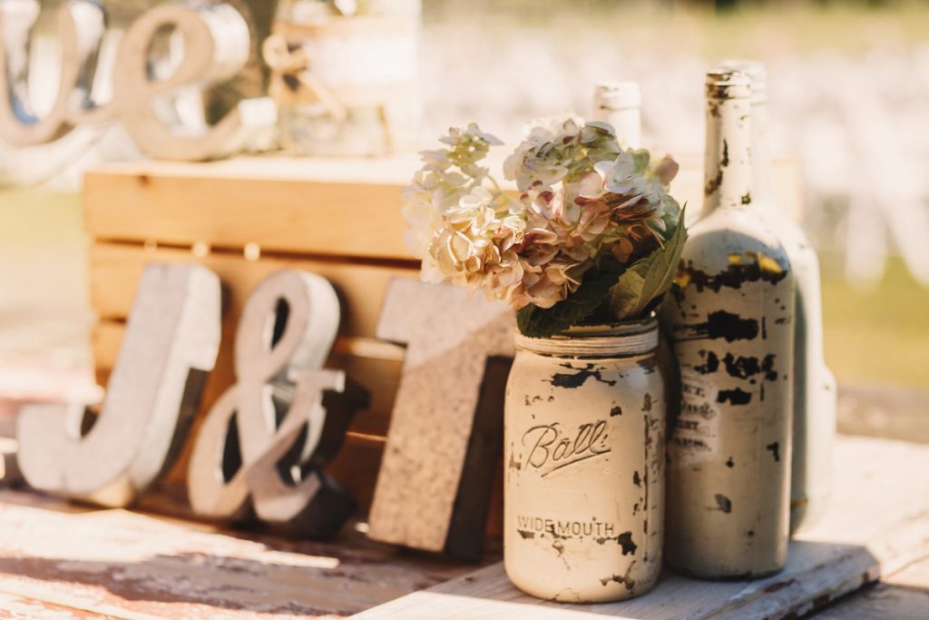 Wedding theme rustic table decor with mason jars flowers vintage wooden details and romantic outdoor setting